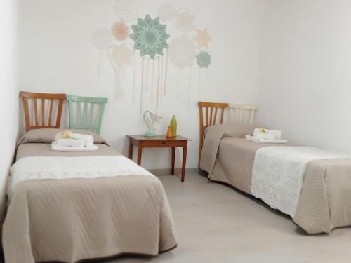 um quarto com duas camas e uma mesa em Ciuri CiuriHome em Balestrate