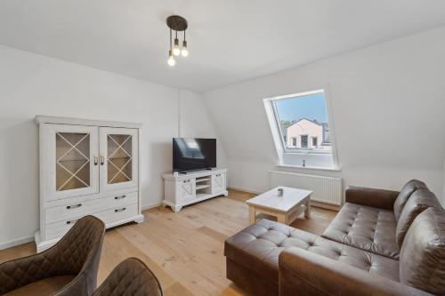 a living room with a couch and a tv at Infinity Stay Ferienapartments Rheinstrasse in Wilhelmshaven