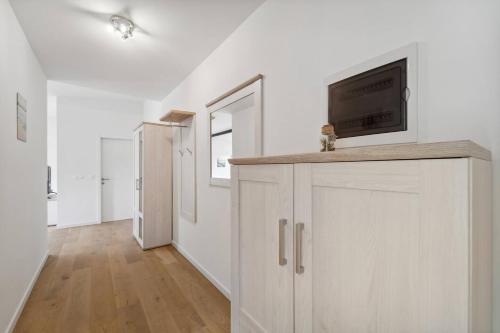 a white room with a tv on top of a cabinet at Infinity Stay Ferienapartments Rheinstrasse in Wilhelmshaven