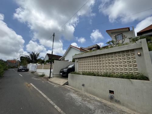 an empty street with a building and cars parked at Pandawa House Bali in Uluwatu