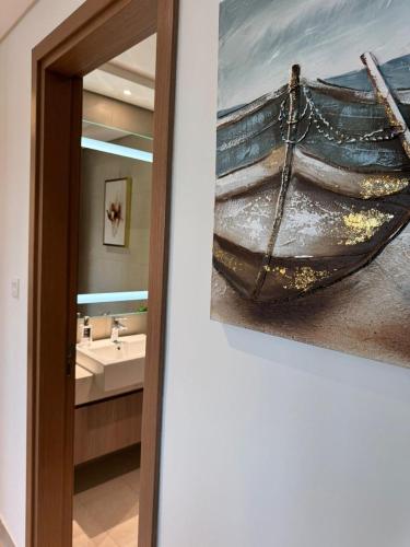 a painting of a boat on the wall in a bathroom at Burj Khalifa view modern 1BHK with balcony in Dubai