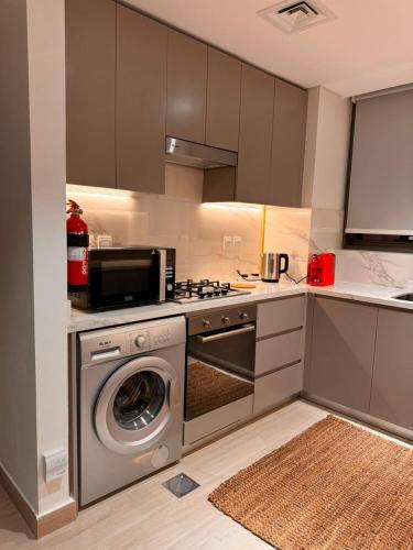 a kitchen with a washing machine and a stove at Burj Khalifa view modern 1BHK with balcony in Dubai