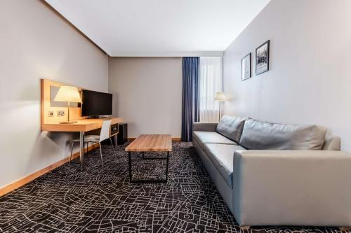 a living room with a couch and a desk at Park Inn by Radisson Peterborough in Peterborough