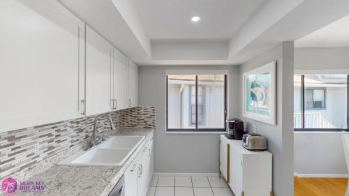 a kitchen with white cabinets and a sink at Beach Rd, 300ft to Beach Access & 500ft to Siesta Key Village, 2bdr & Studio in Siesta Key
