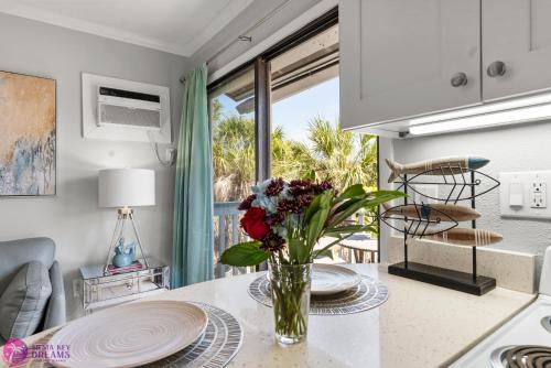 a kitchen with a table with a vase of flowers on it at Beach Rd, 300ft to Beach Access & 500ft to Siesta Key Village, 2bdr & Studio in Siesta Key