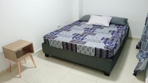 a bedroom with a bed and a small table at Apartamento Con Excelente Ubicacion en Cali in Cali