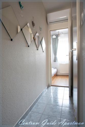 a hallway with a staircase in a house at Centrum Guide Apartman Hévíz in Hévíz