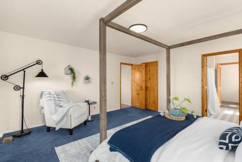 a bedroom with a large bed and a chair at Puget Sound Sunset - Whidbey Ocean Front home with C in Oak Harbor