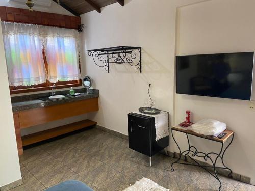 a room with a television and a table with a window at Casarão Coimbra Pousada Colonial in Pirenópolis