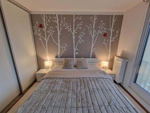 a bedroom with a bed with red flowers on the wall at Waldorf Apartment in Ljubljana