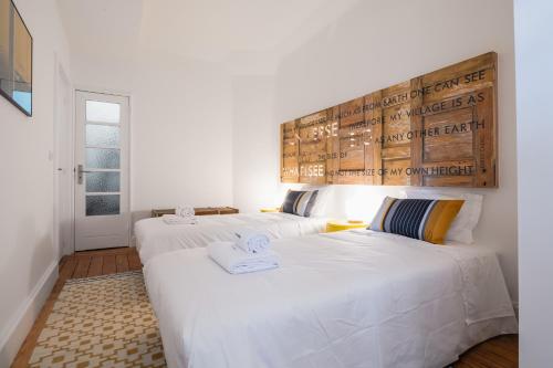 two beds in a room with white walls at PortoSoul Formosa in Porto