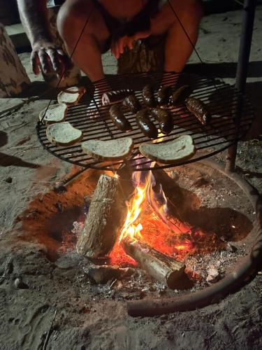 una persona che cucina cibo su una griglia sopra un fuoco di Zacisze obok Suntago Park a Grabce