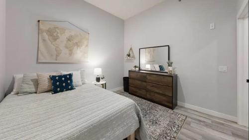 a white bedroom with a large bed and a dresser at Sweet Martini on Lake Kampeska in Watertown