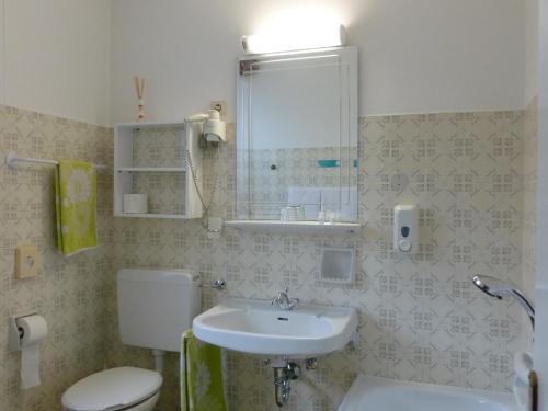 a bathroom with a sink and a toilet at LAKE & RIVER Hotel in Carezza al Lago