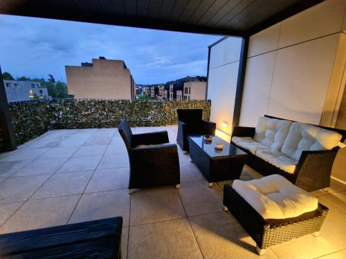 a patio with chairs and a couch on a balcony at Waldorf Apartment in Ljubljana