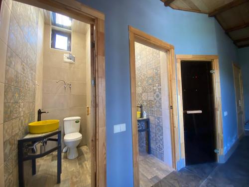 a bathroom with a yellow sink and a toilet at Bloom House in Zovuni