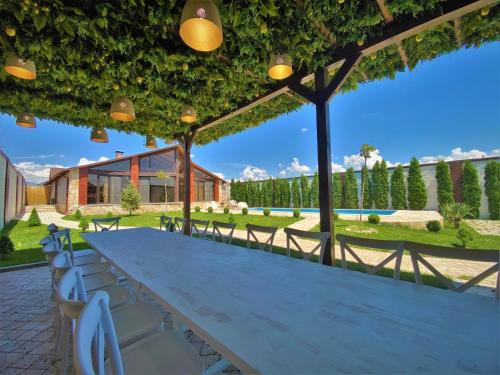 a long table and chairs under a pergola at Bloom House in Zovuni