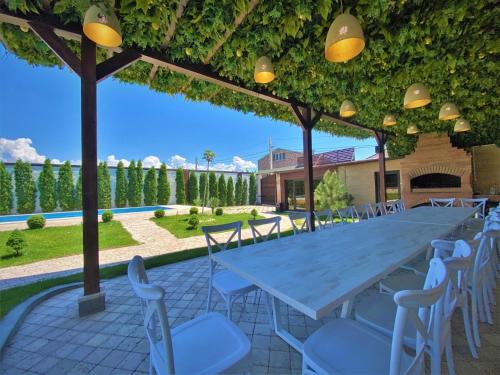 a long table and chairs under a pergola at Bloom House in Zovuni