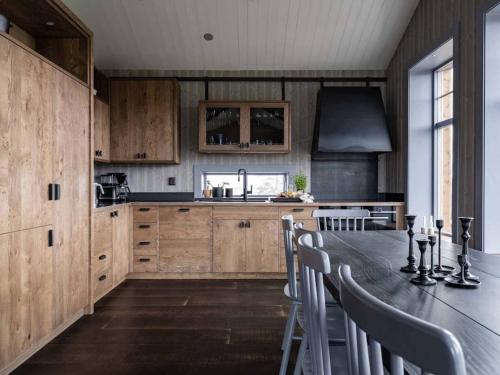 a kitchen with wooden cabinets and a table with chairs at Kopparvillan 37B - Åre Valley Lodges in Åre