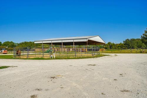 a stable with a large building with horses in it at Dog-Friendly Guest House on Horse Ranch in Azle! in Azle