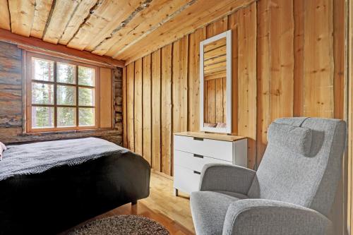 a bedroom with a bed and a chair and a mirror at Bliss Adventure Lodge in Pyhätunturi