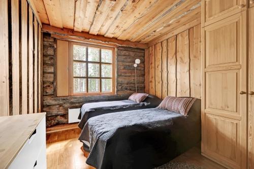 a room with two beds in a log cabin at Bliss Adventure Lodge in Pyhätunturi