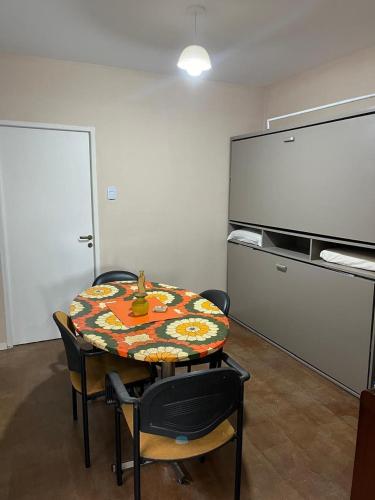a room with a table and chairs and a chalkboard at Rufina Departamentos in San Juan