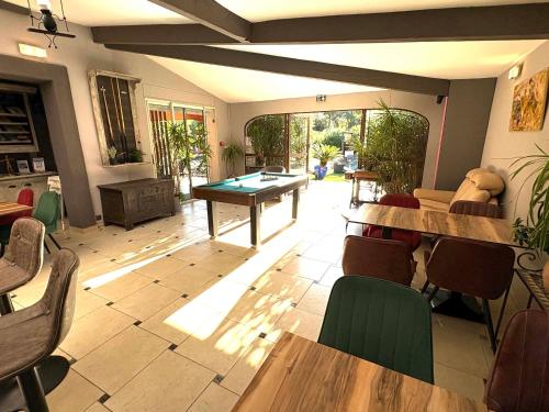 a living room with a ping pong table and chairs at GuestHouse Le Patio34 in Lavérune