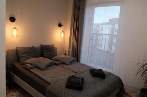 łóżko w pokoju z dużym oknem w obiekcie Apartments Space and More, Dmowskiego - 20 minut do RYNKU, Self Check-In 24H, Parking we Wrocławiu