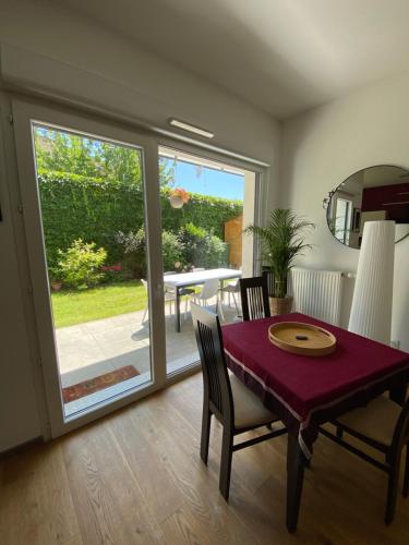 une salle à manger avec une table et des chaises rouges ainsi qu'une terrasse dans l'établissement Strasbourg 3 pièces 