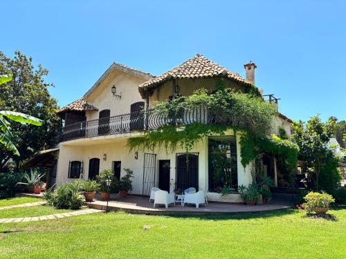 a house with two white chairs in the yard at Villa Elisa - Luxury and Style by the Sea in Fontane Bianche