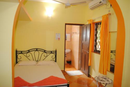 a bedroom with a bed in a room with a bathroom at Joe And Marietta's Guesthouse in Calangute