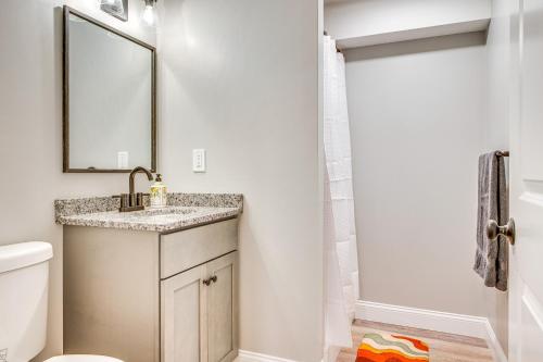 a bathroom with a sink and a toilet and a mirror at Walk to Beaches and Parks Home with Deck in Laconia in Laconia