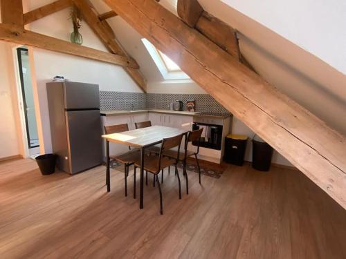 une cuisine avec une table et un réfrigérateur dans l'établissement Appartement proche plage, à Dunkerque