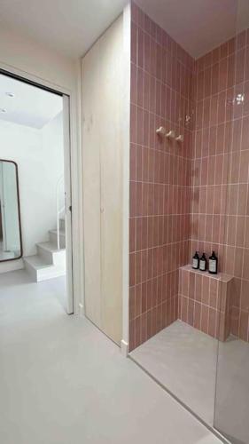 une salle de bain avec une douche avec une porte vitrée dans l'établissement LA GRANDE JANE petite villa bord de mer, à Borgo