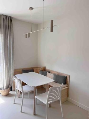 - une table et des chaises blanches dans la chambre dans l'établissement LA GRANDE JANE petite villa bord de mer, à Borgo