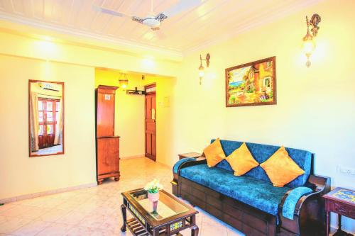 a living room with a blue couch and a table at 'Golden Sea Pearl' 1 bhk Beach apartment in Benaulim