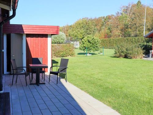a patio with chairs and a table and a lawn at Amazing holiday home in the nature-By Traum in Laholm