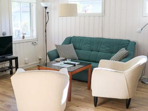 a living room with a green couch and two chairs at Amazing holiday home in the nature-By Traum in Laholm