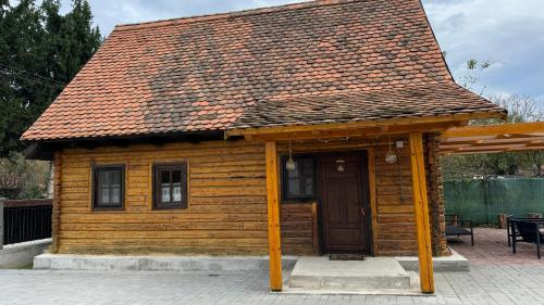 a small wooden cabin with a brown roof at Căsuța cu tihnă in Porumbacu de Sus