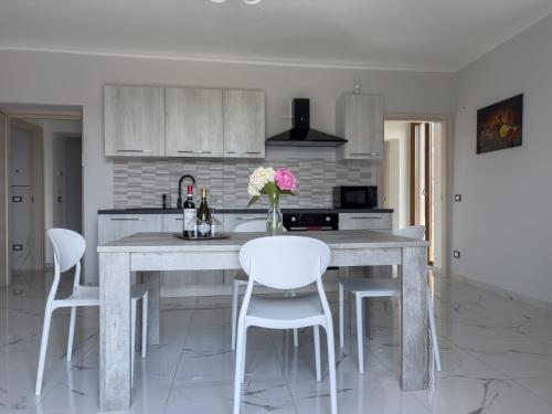 a kitchen with a large table with white chairs at Roero Sunset in Govone