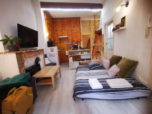 un salon avec un lit et une cuisine dans l'établissement Appartement cosy cœur historique de Montpellier, à Montpellier