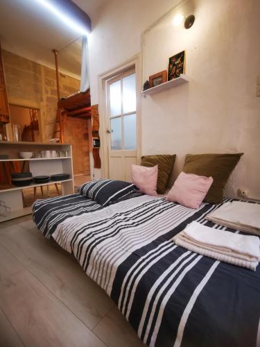 une chambre avec un grand lit avec des oreillers roses dans l'établissement Appartement cosy cœur historique de Montpellier, à Montpellier