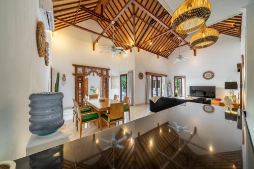 a dining room and living room with a table and chairs at Villa Nemia Seminyak in Seminyak