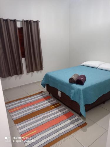a bedroom with a bed with a blue blanket at Casa da Arvore in Mariana
