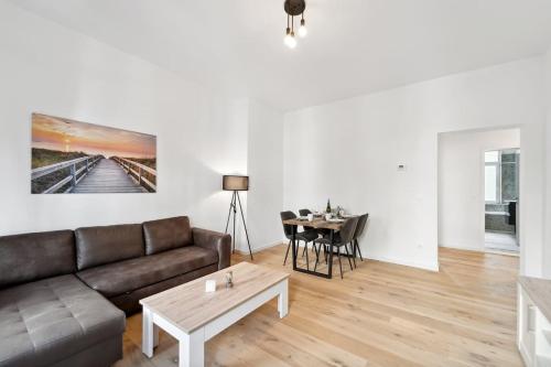 a living room with a couch and a table at Infinity Stay Ferienapartments Rheinstrasse in Wilhelmshaven