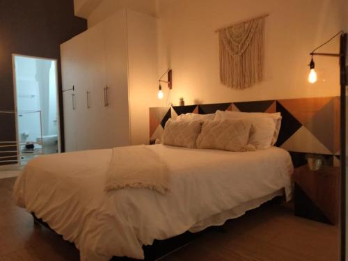 a bedroom with a large bed with white sheets and pillows at Cómodo Departamento en Donceles al lado de Bellas Artes! in Mexico City
