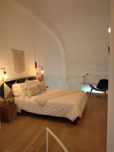 a bedroom with a large white bed and a chair at Cómodo Departamento en Donceles al lado de Bellas Artes! in Mexico City