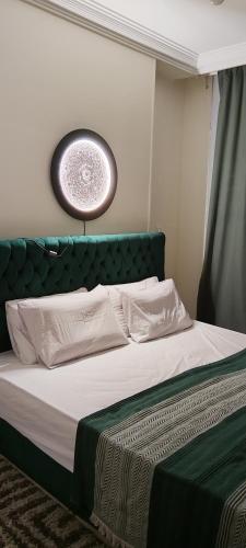 Una cama con cabecero verde en un dormitorio. en The Location - Luxury apartments in cairo, en El Cairo