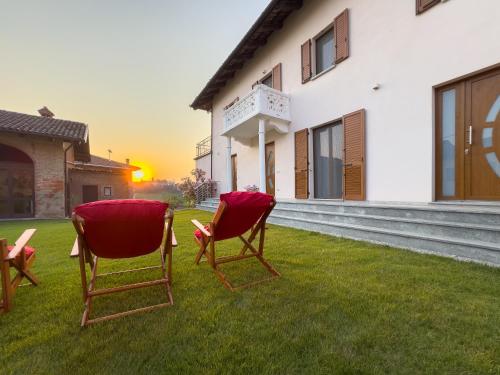 two chairs sitting on the grass in front of a house at Roero Sunset in Govone